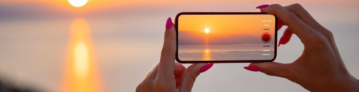 Mujer tomando la foto del atardecer 